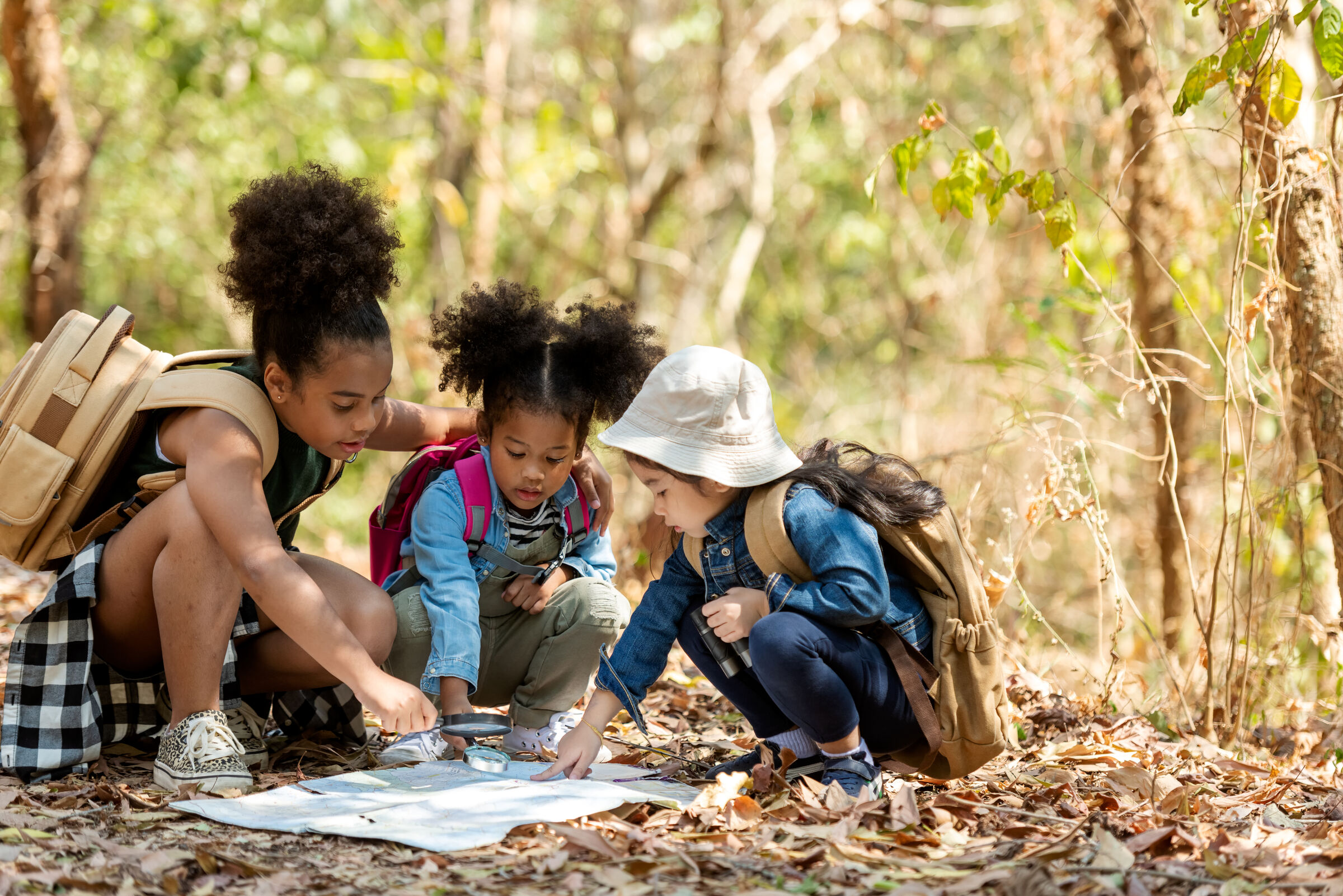 An older child reading a map on the trail, navigating the Hyphae House land